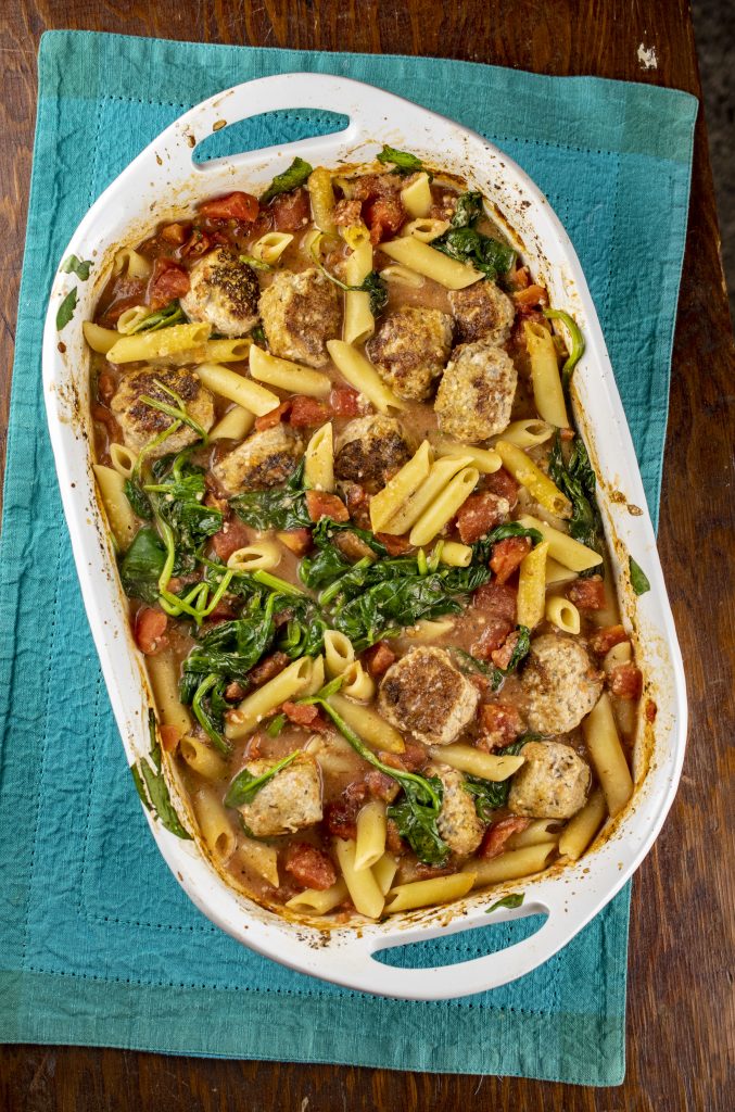 Penne in tomato cream sauce with meatballs and spinach